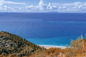 white clouds over blue sea at horizon