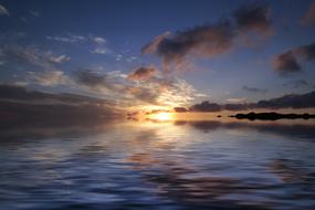 evening sky with sun on the horizon over the sea