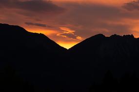 Beautiful landscape with silhouettes of the mountains, at colorful and beautiful sunrise in the clouds