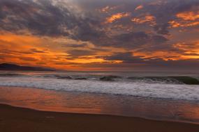 grey clouds at red sunset sky over Beach