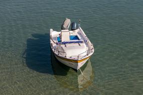 Colorful, little boat on the beautiful and colorful, clear water in sunlight
