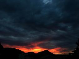 dark clouds over mountains at Sunset