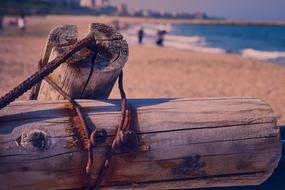 Old, rusty, wooden and metal construction on the sandy beach with waves