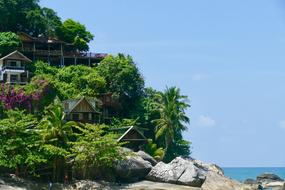 Beautiful and colorful coast of Ko Phangan, Thailand, with buildings, plants and rocks