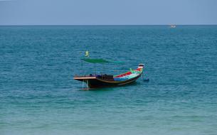 Colorful boat on the beautiful and colorful sea with ripple, at background with another boat, in Ko Phangan, Thailand