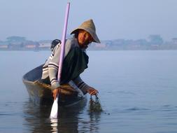 Fishermen on the boat, on the Lake Inle in Vietnam, in fog, at the dawn