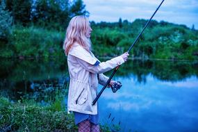 girl with a fishing rod in the blue twilight