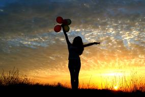 silhouette Girl With Balloons At Sunset