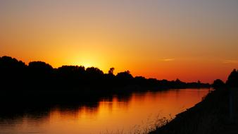 Beautiful landscape of Sacramento River, among the shore with silhouettes, at colorful and beautiful sunset