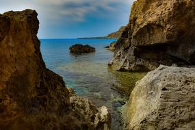 Beautiful and colorful Cavo Greko with rocks among the water, in Cyprus, Greece, under the blue sky with clouds