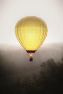 yellow hot air balloon in the fog