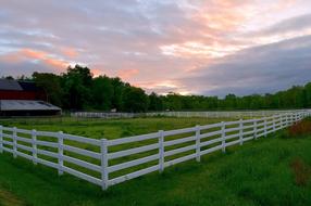 white fence along the pasture on the farm