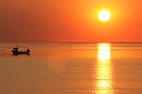 empty boat, reflection of the golden sun in the sea at sunset