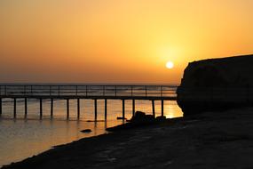 panorama of the beach and pier on the background of a yellow sunset in Egypt