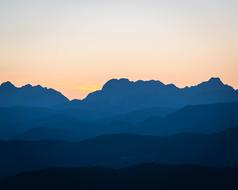 layered blue mountains and pink sky