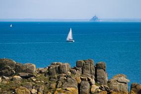 rocky coast and white sailing ship