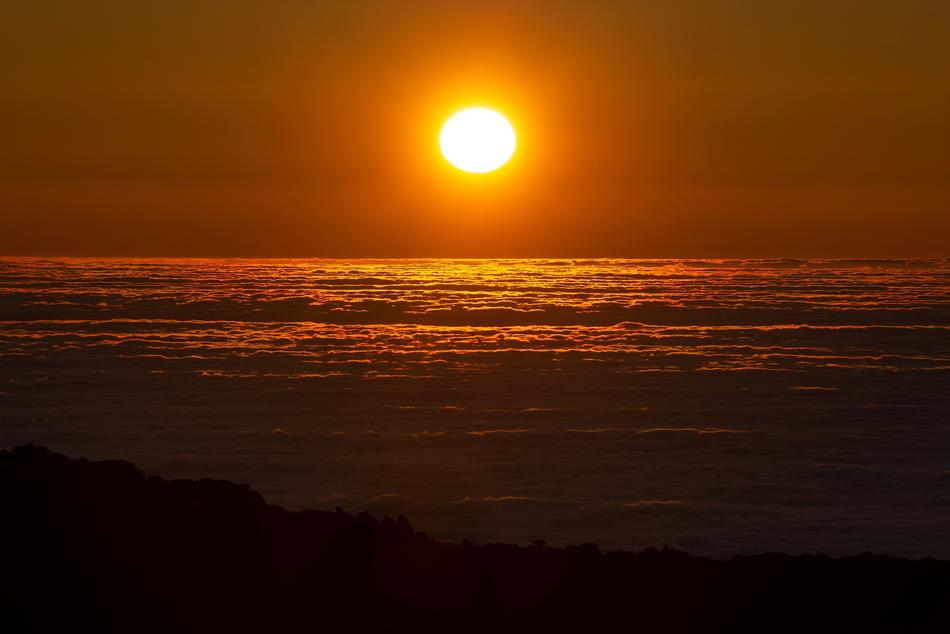 bright sun at sunset over water at dusk