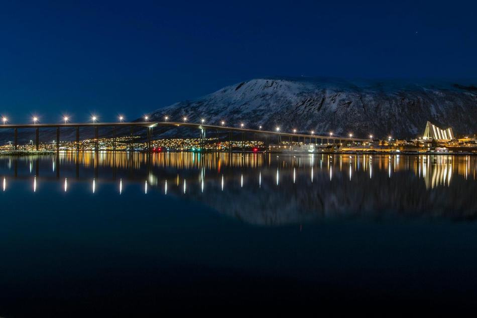 Beautiful and colorful coast of the water, with colorful lights, buildings and mountain, in the evening