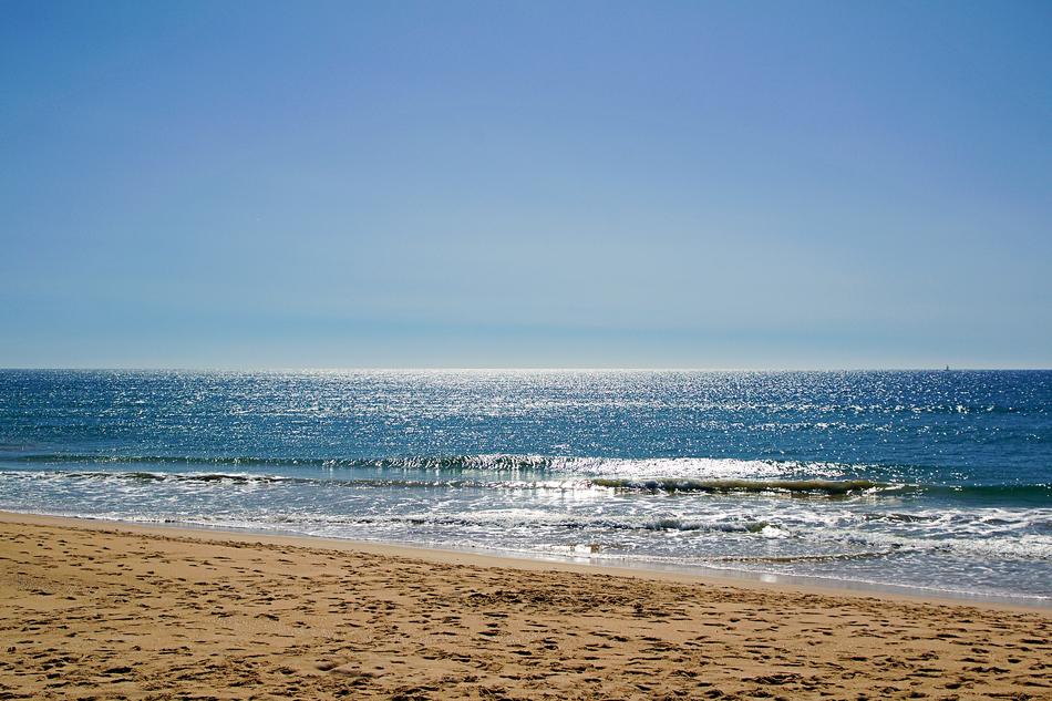 Beautiful sandy beach of Faro, Algarve, Portugal, in sunlight