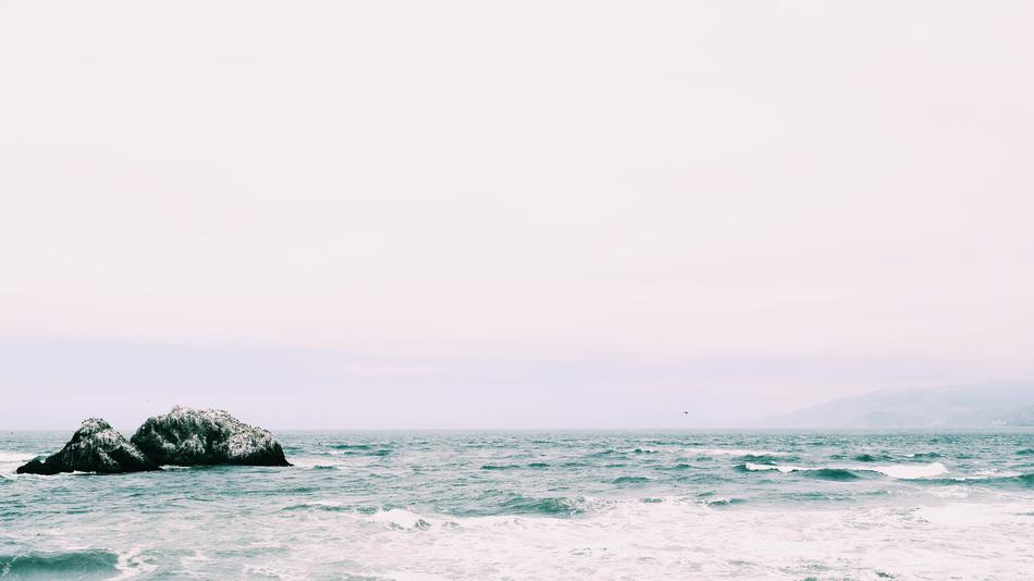 distant view of rocks in ocean in blurred background