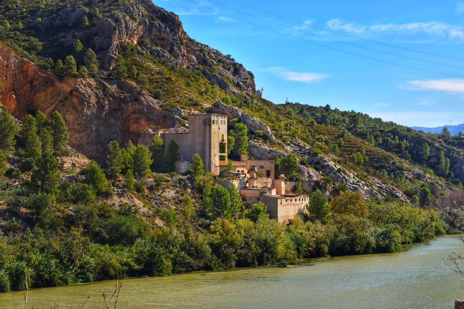 stone buildings near the mountain next to green plants