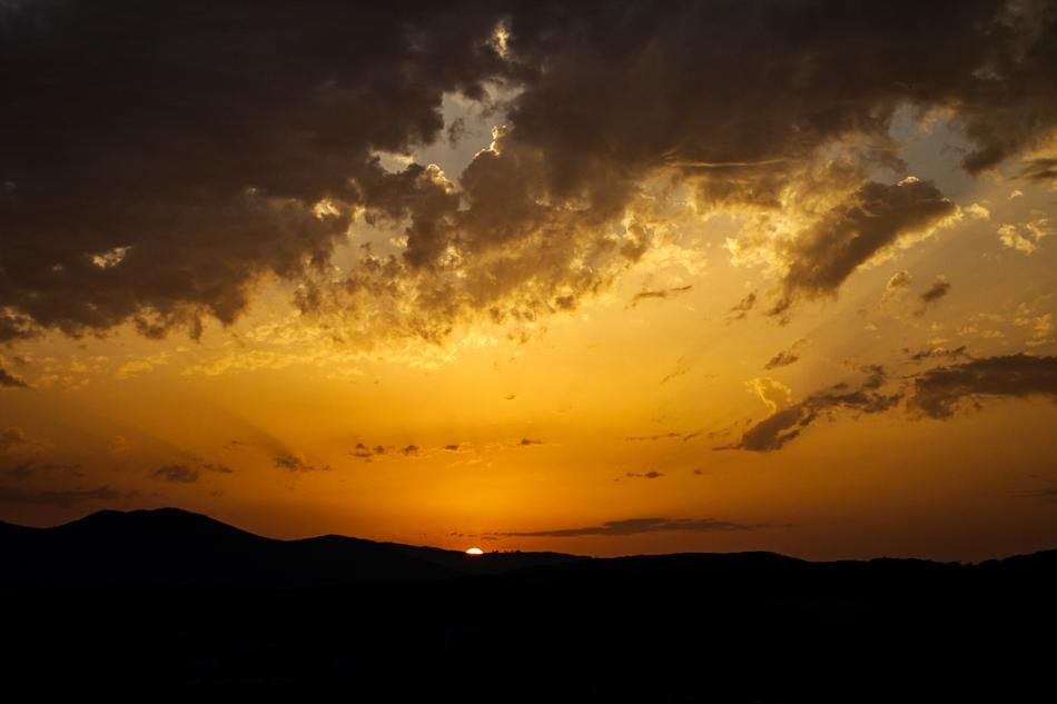 evening clouds over silhouettes of black mountains