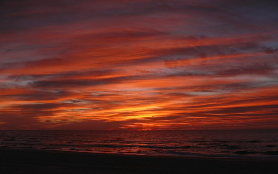 clouds in the orange sky over the sea during sunset