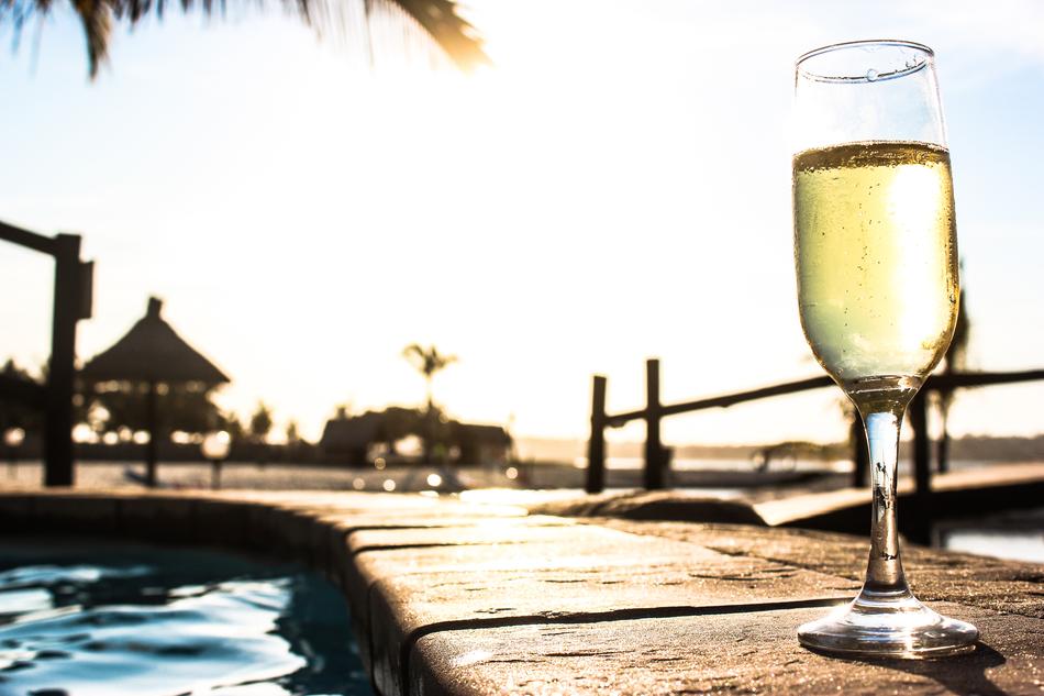 glass of champagne near the pool at the resort in a blurred background