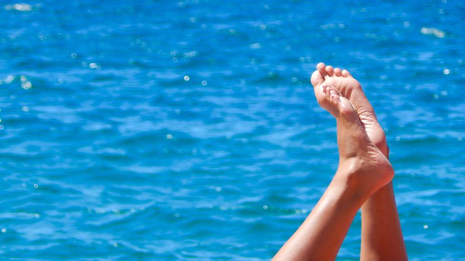 bare feet on the background of the blue sea