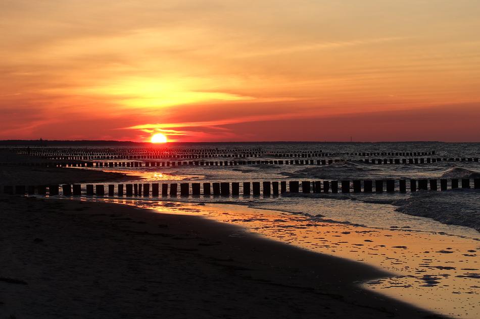 breakwaters on a yellow-red sunset background