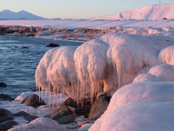 Ocean Wave and snowy coast at Sunset