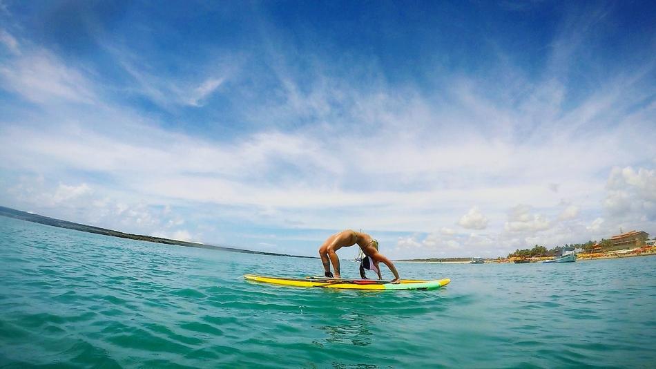 girl doing yoga on a surfboard