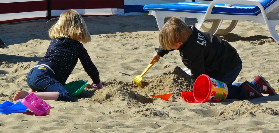 children playing in the sandbox on the beach