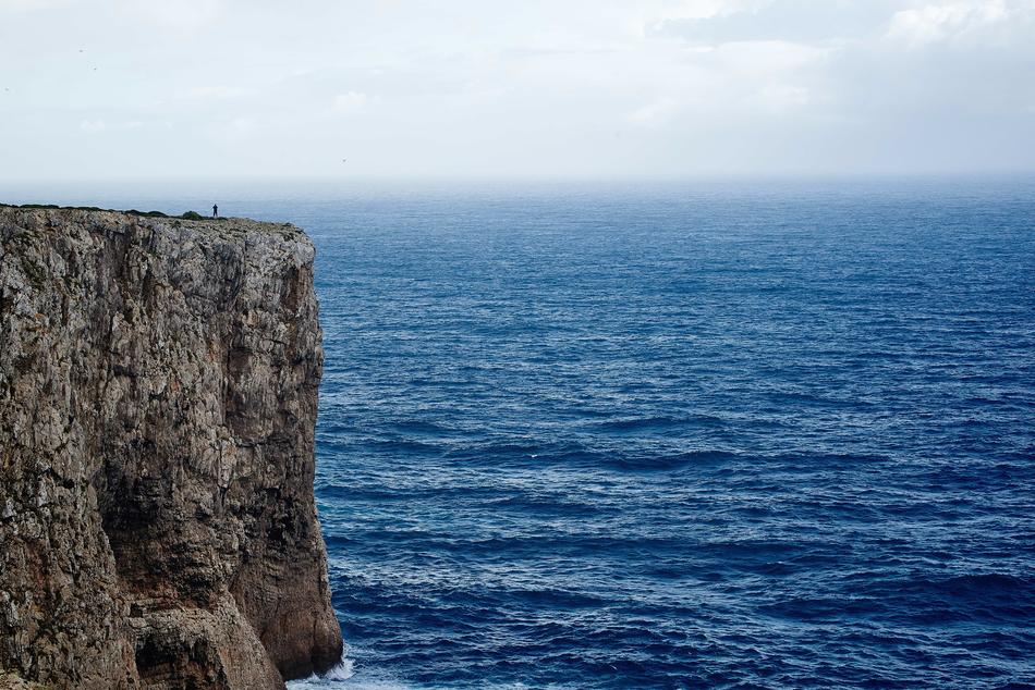 distant Person on Sheer Cliff at sea