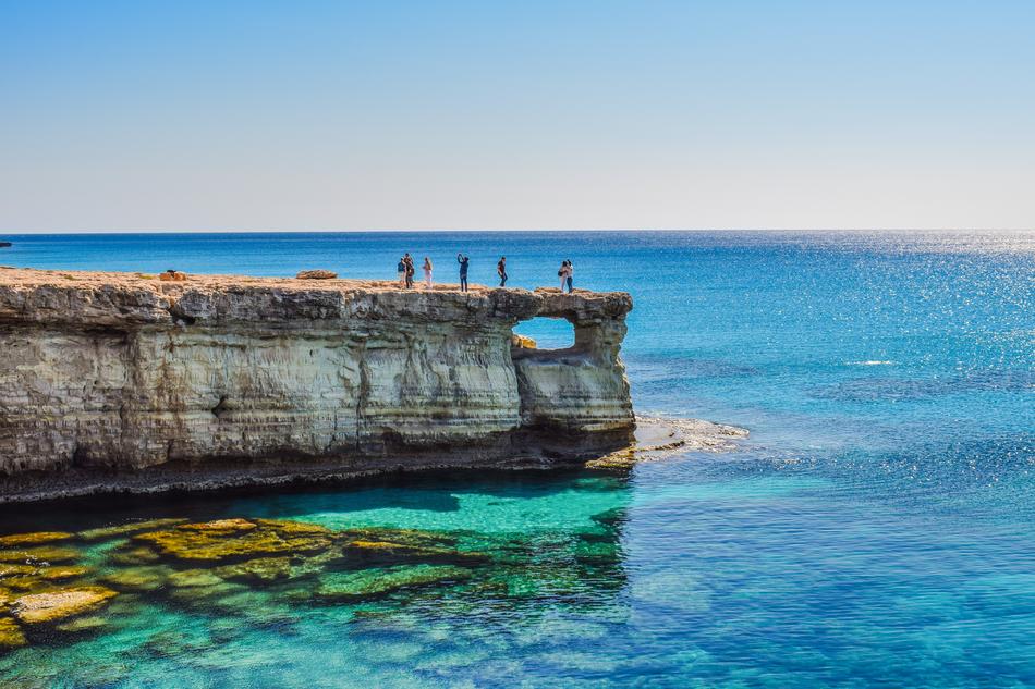people on cliff over Sea Caves, Cyprus, Cavo Greco