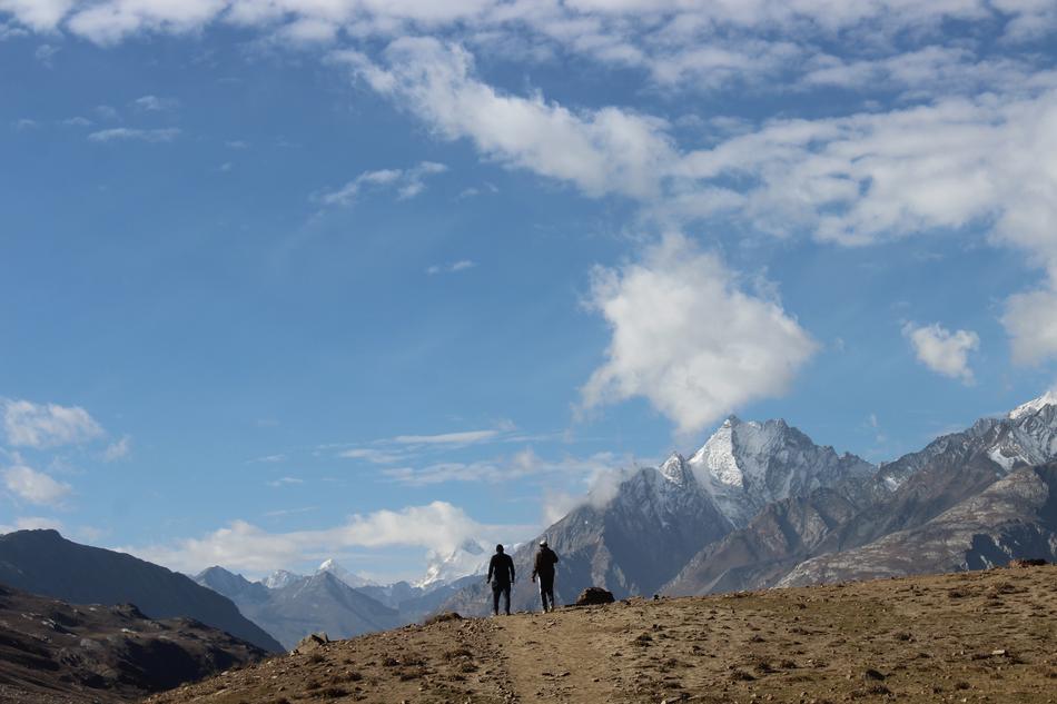 two men on path in view of scenic mountain peaks