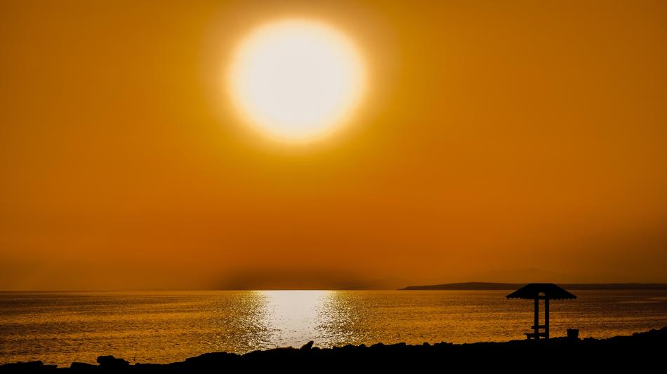 beach umbrella on orange sunset background