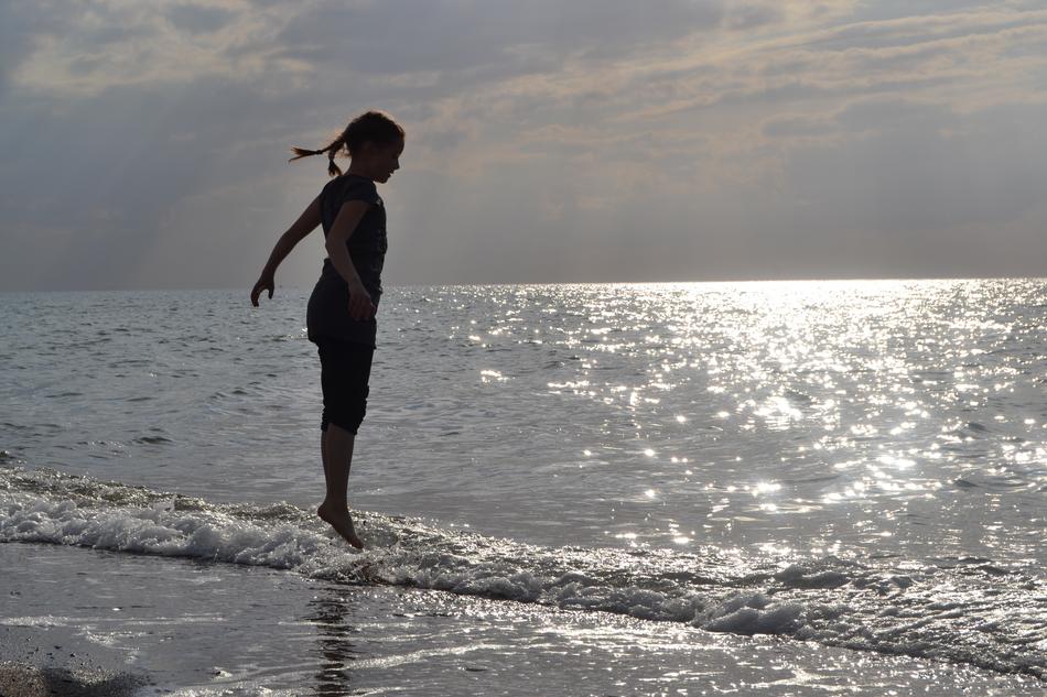 silhouette of a girl standing on the seashore