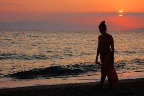 silhouette of a girl on the beach by the sea
