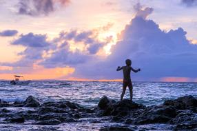 Silhouette of a man on a rock by the sea