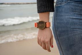 womans hand with a watch against the sea