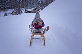 a child sledding in the snow