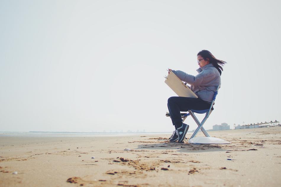 girl drawing Sketch on sand beach at sea