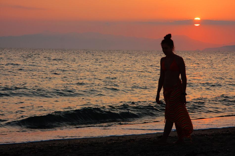 silhouette of a girl on the beach by the sea