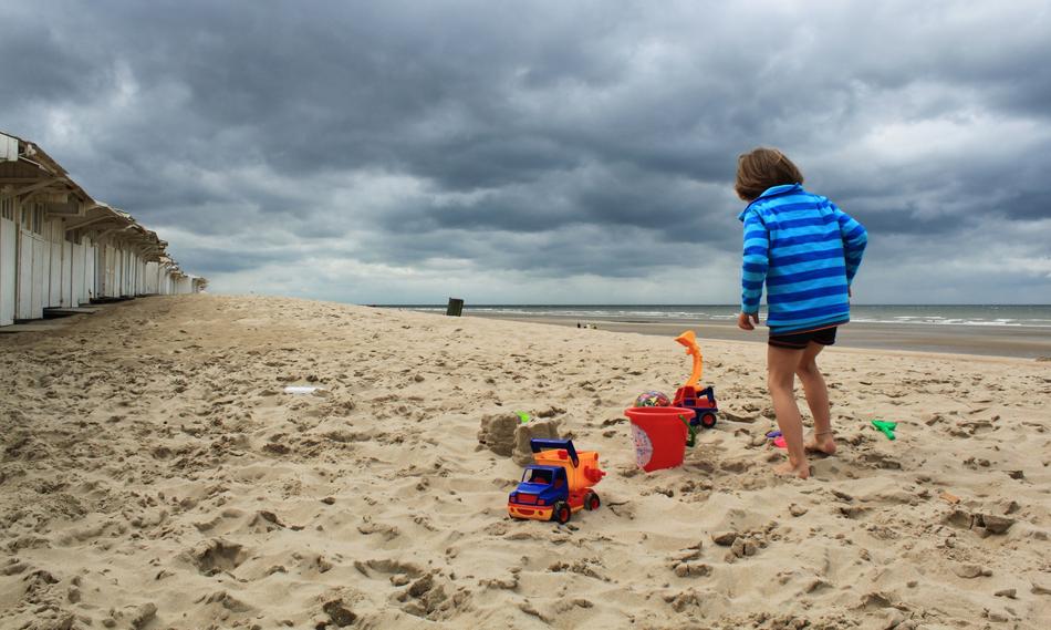 the baby is happy by the sand