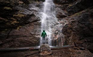 man standing by a waterfall