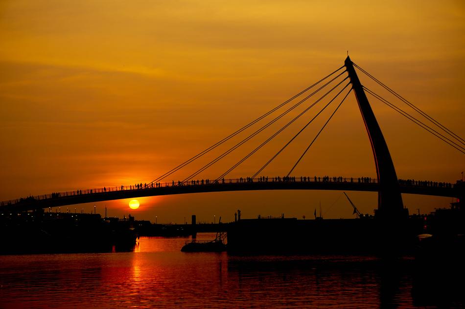 Bridge against the backdrop of a bright red sunset free image download