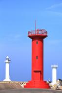 red lighthouse building on the beach