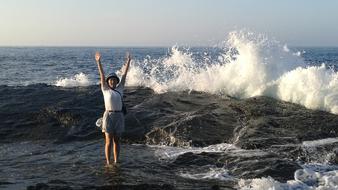 Girl on the waves on the rocks