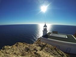 white lighthouse in the sun by the sea